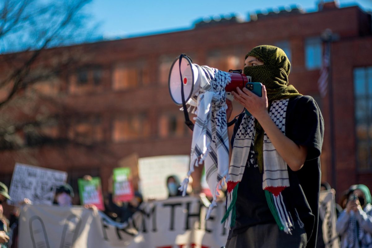 A demonstrator speaks to the crowd at a protest against GWs reported ties to Israel on Saturday.