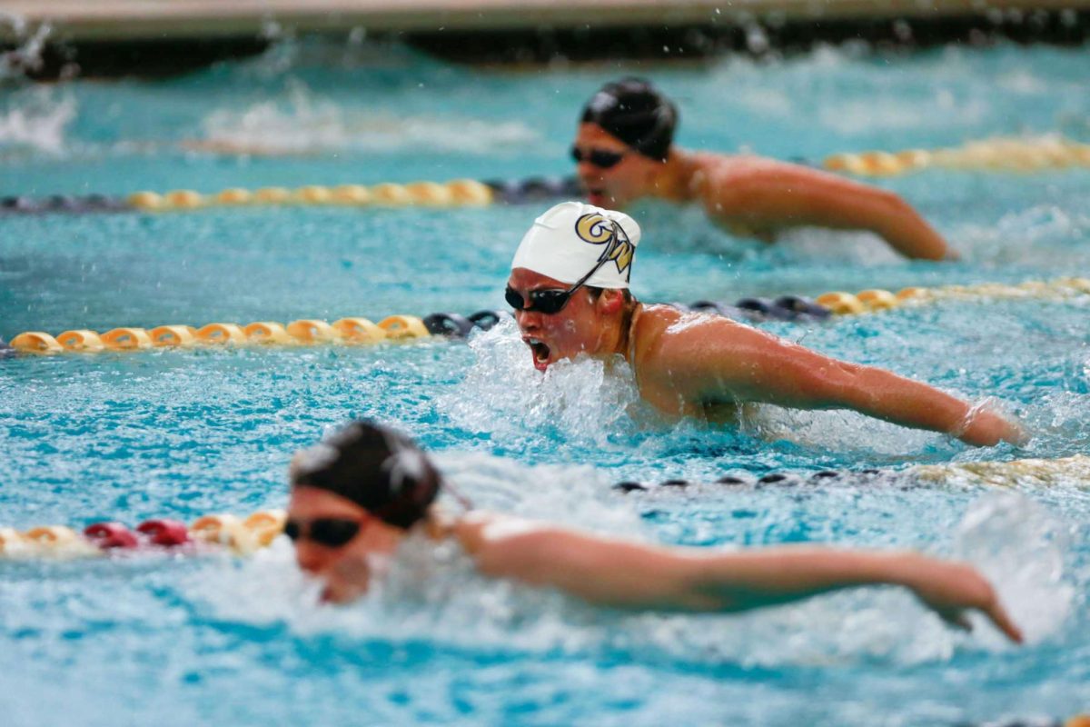 Swimmers cut through the water during a meet.
