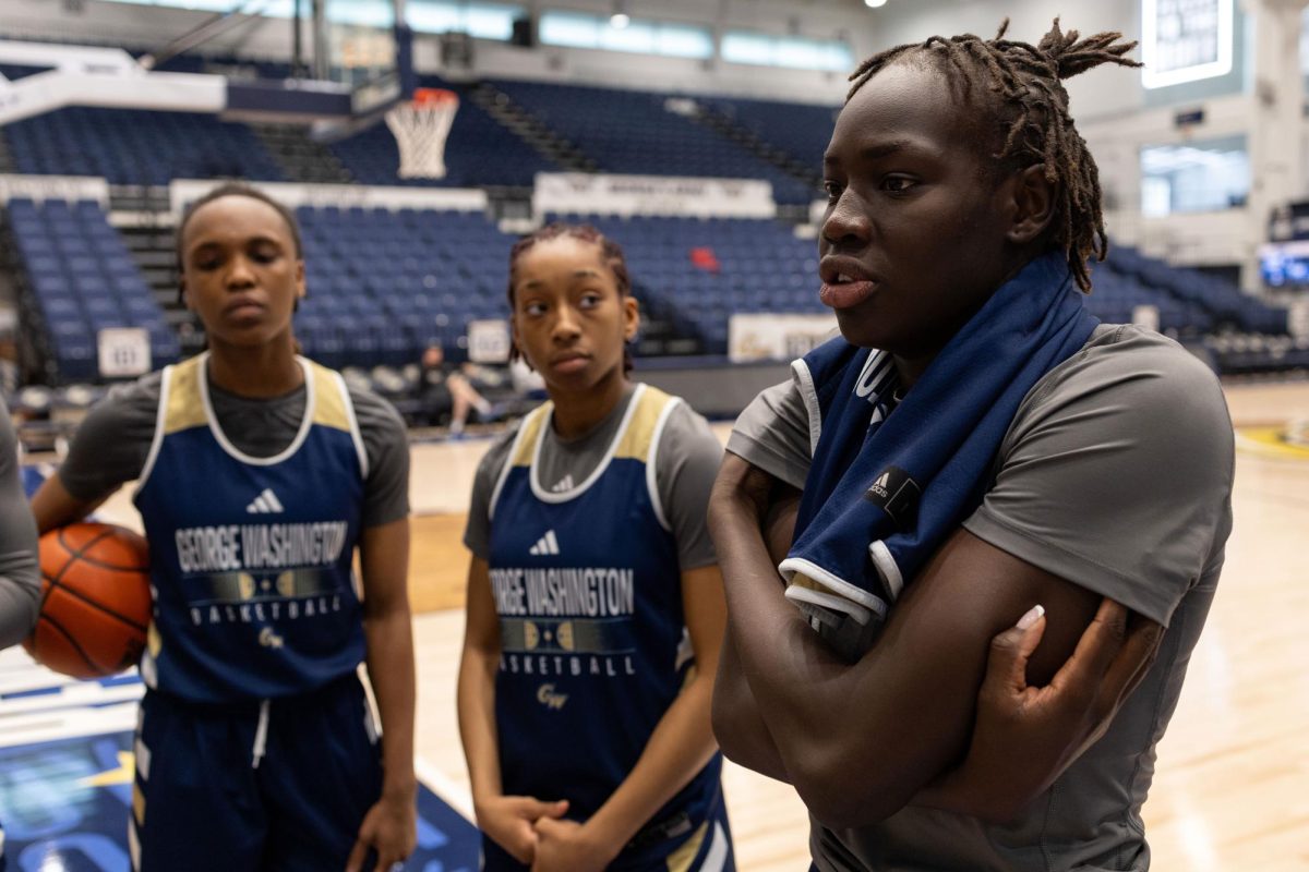From left to right, Asjah Inniss, Nya Robertson and Nya Lok chat on the court. 