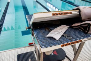 A wrench lies on a swimmers block next to the Smith Center swimming pool.