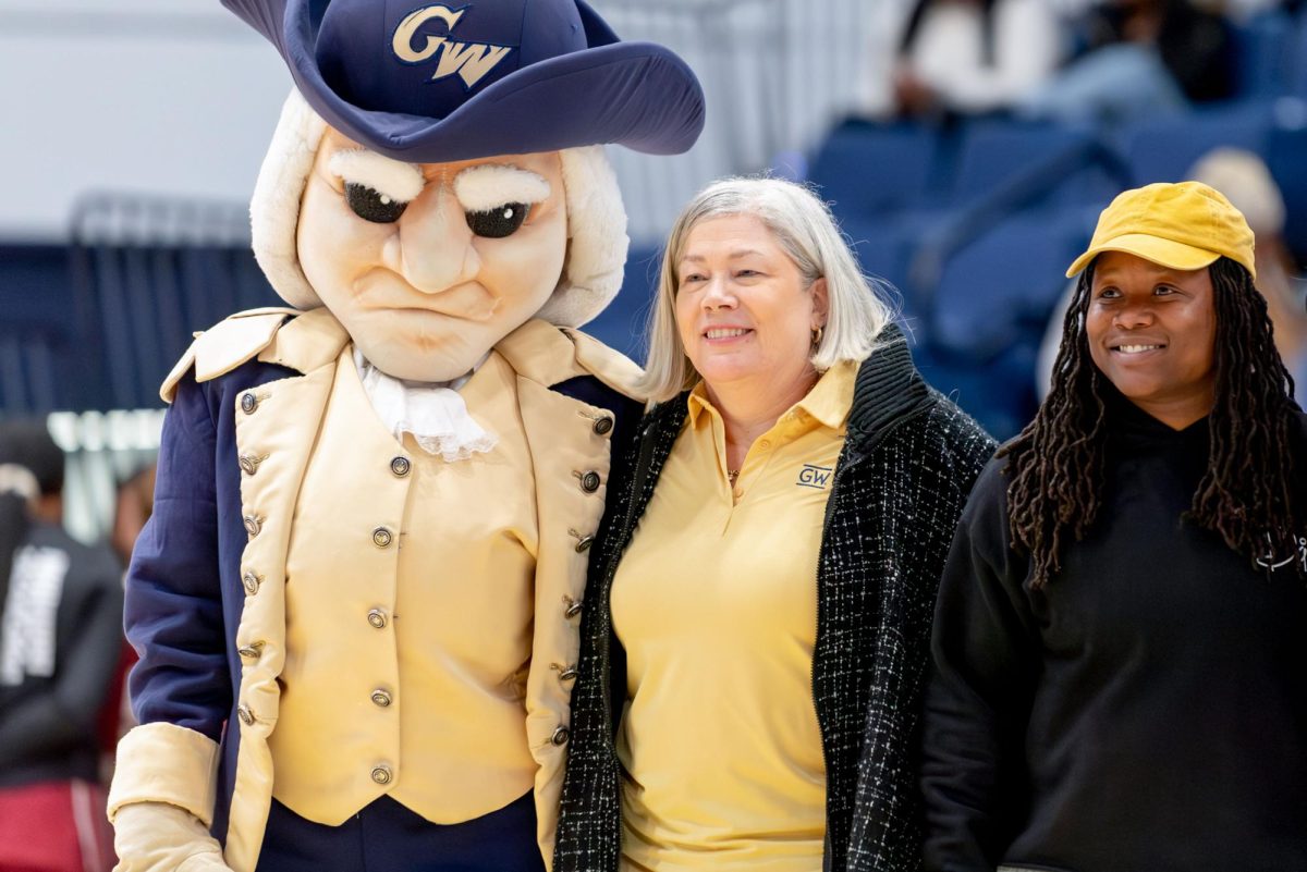 President Ellen Granberg poses with George attendees at a basketball game.