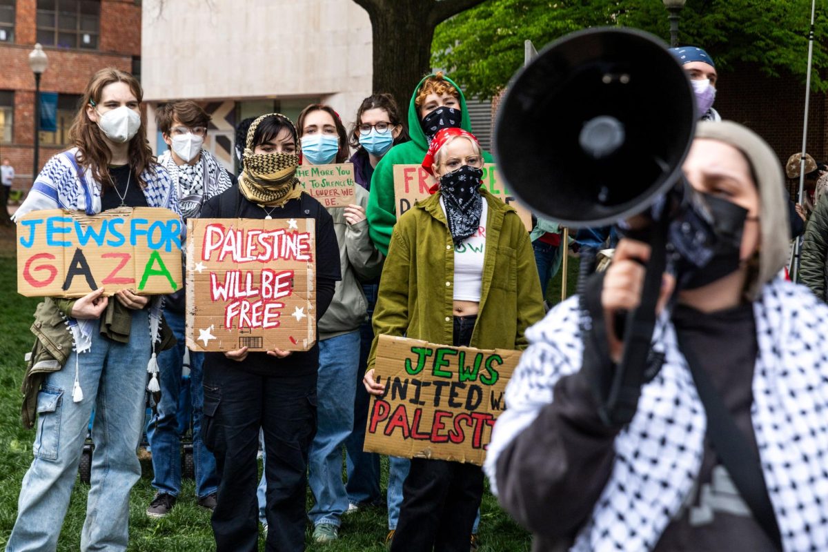Demonstrators stand with pro-Palestinian signs during an encampment protest.