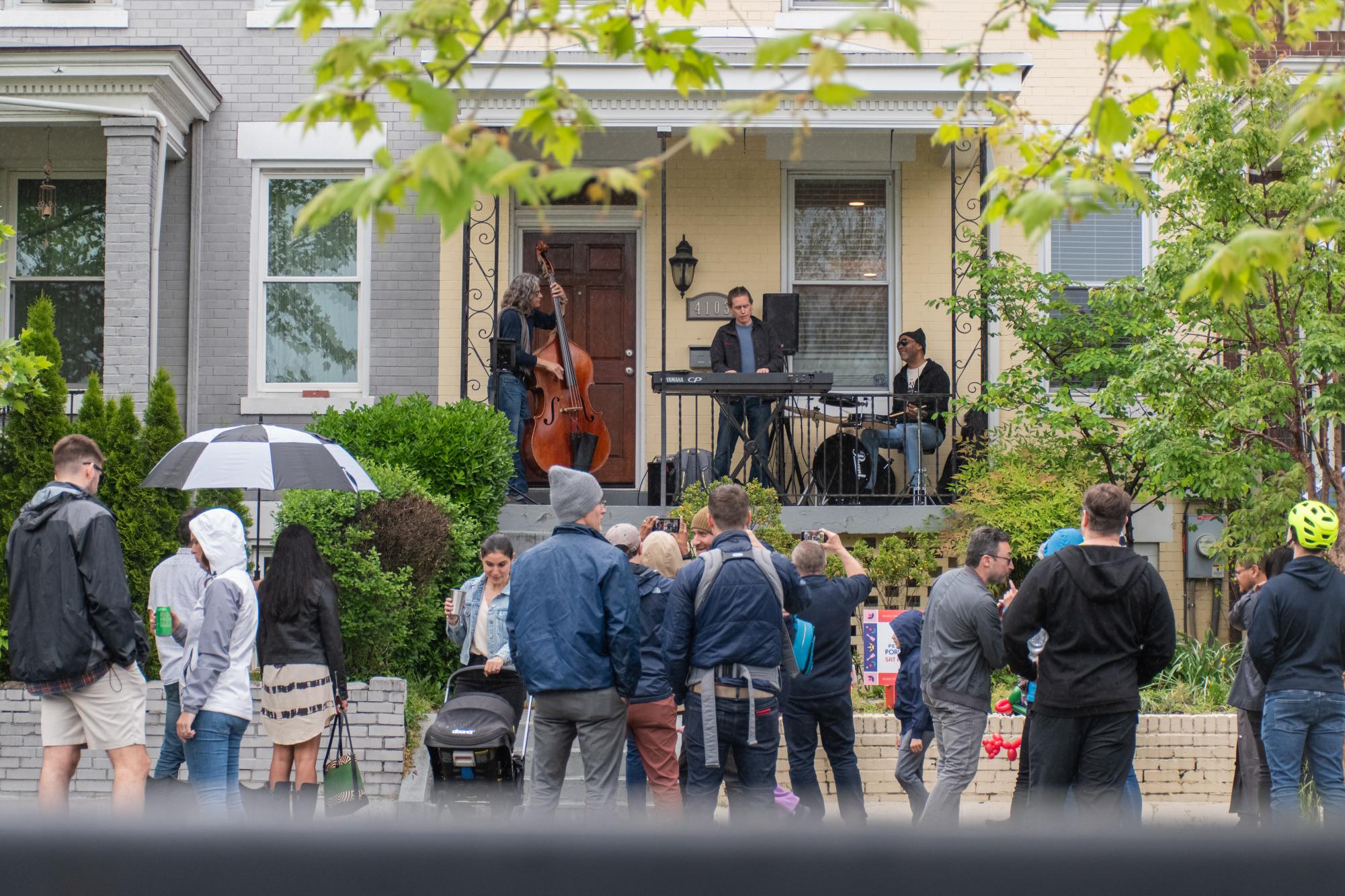 A crowd forms in front of the Jay Frost Trio, a local jazz ensemble.