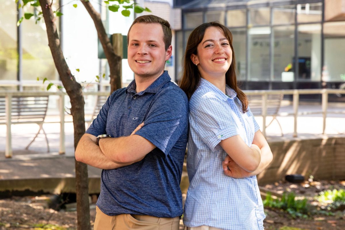 Arielle Geismar and Demetrius Apostolis, the former Student Government Association president and vice president, stand back to back.