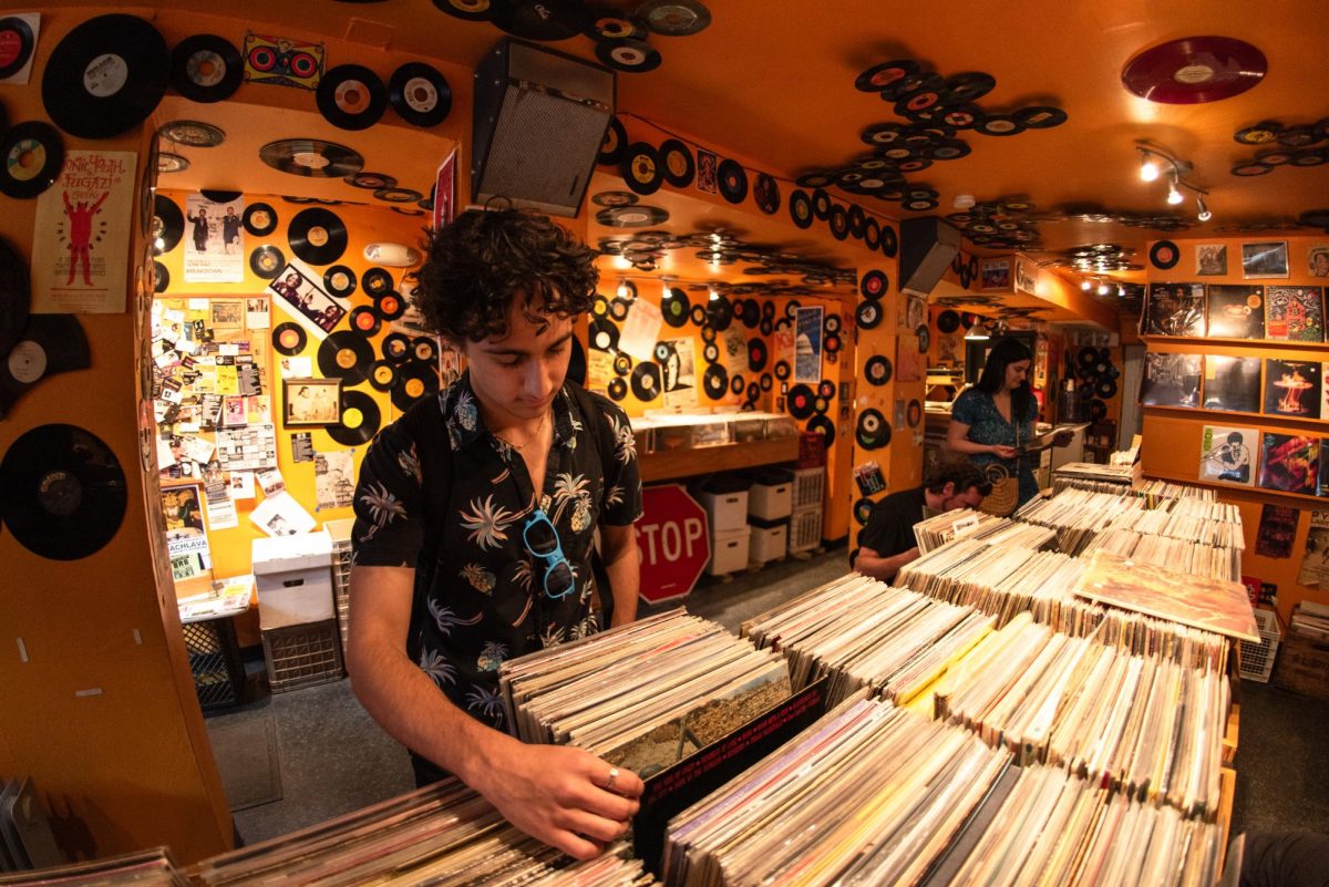 A patron flips through vinyl records at Som Records on 14th Street.