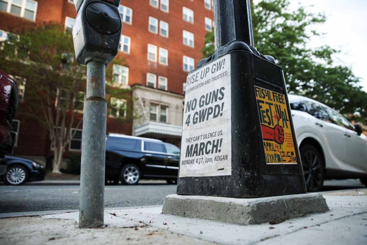 An old poster protesting the arming of GWPD sits at the base of a lamp post.
