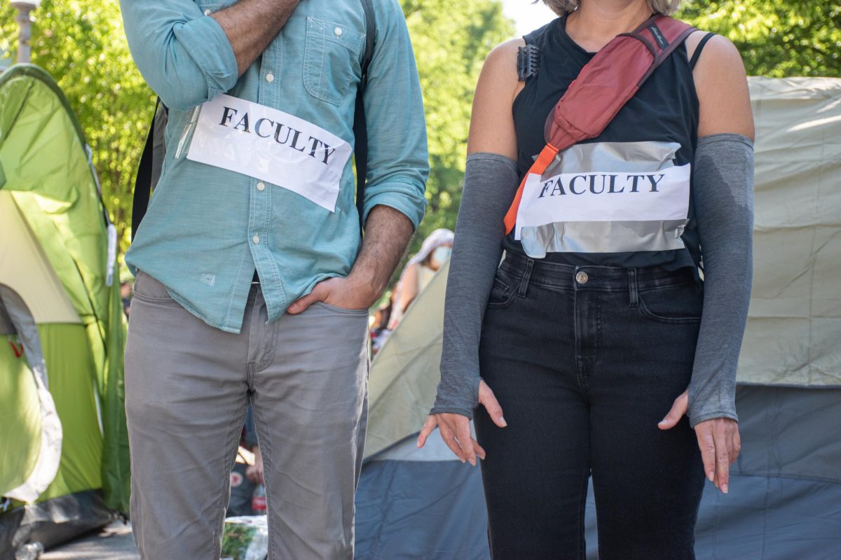 Faculty protesters attend the University Yard demonstration with signs.