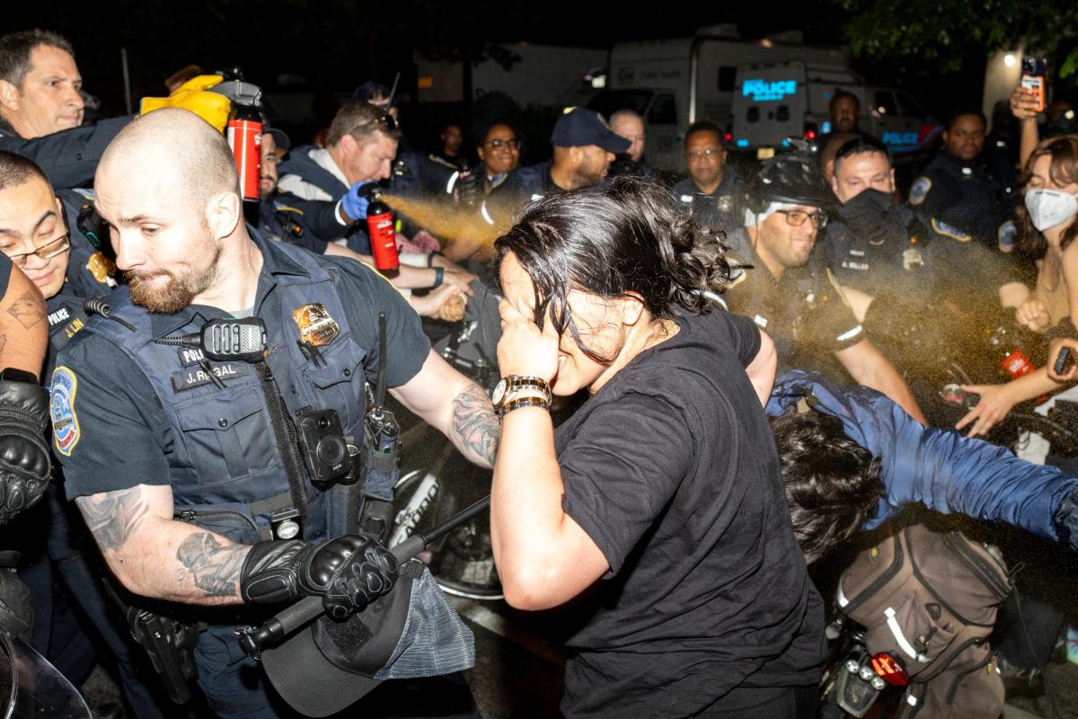 Metropolitan Police Department officers deploy pepper spray on a crowd of demonstrators at the barricades police erected during their sweep of the encampment.