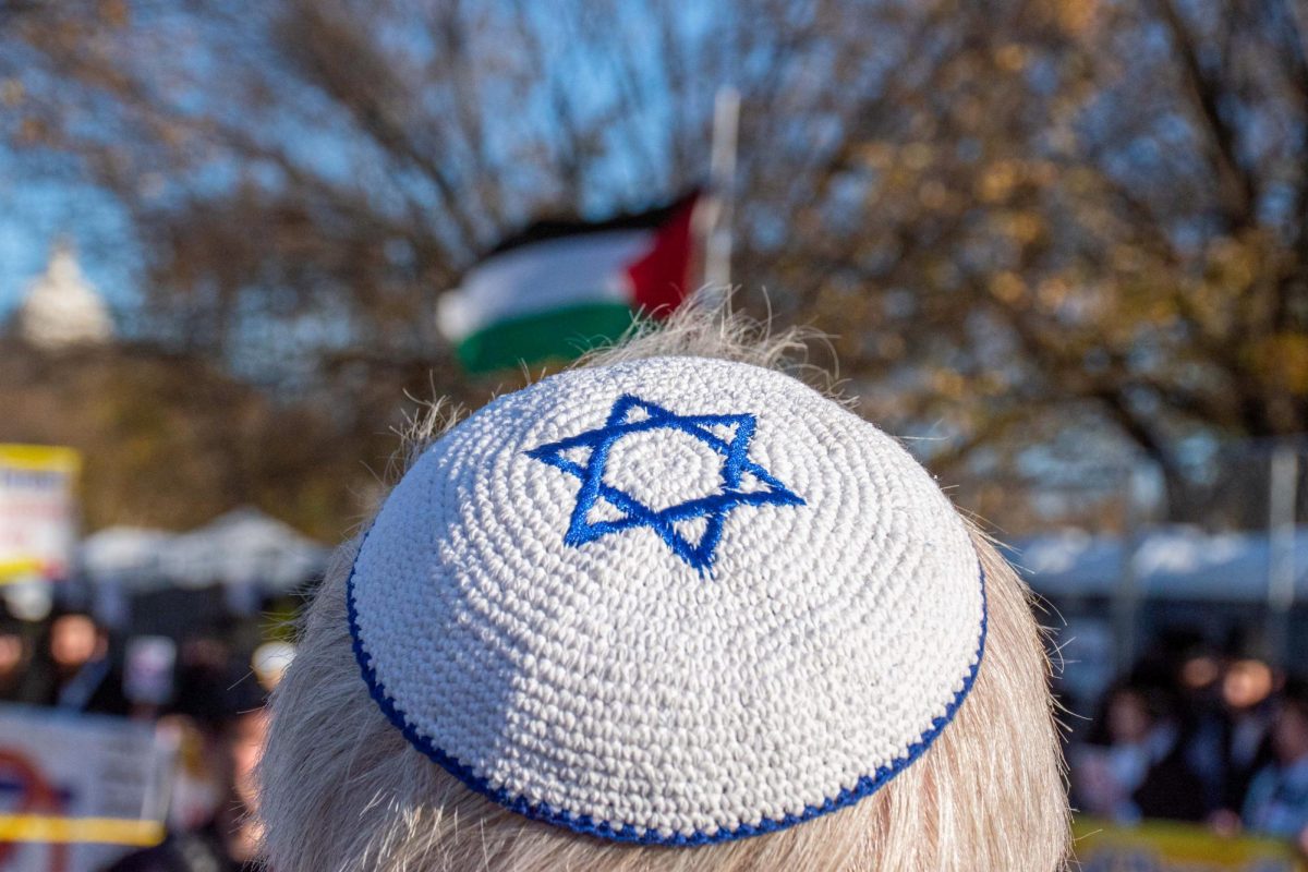 A protester wearing a kippah looks toward a Palestinian flag at a rally in November.