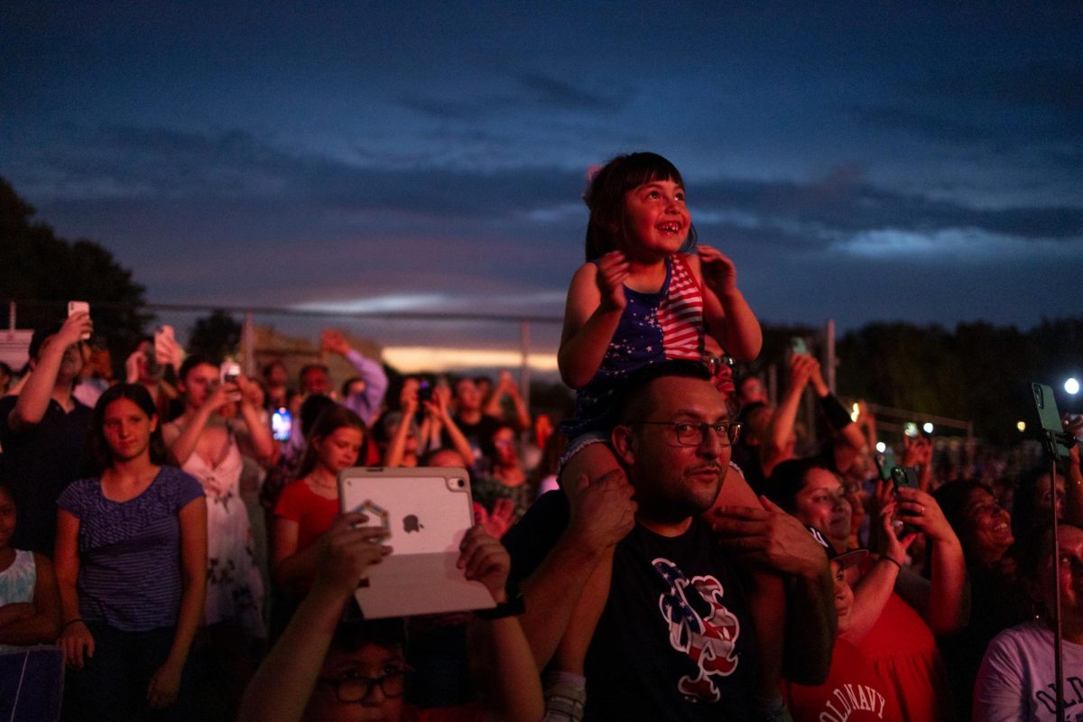 Atop her fathers shoulders, a girl smiles at the fireworks during the National Mall fireworks display.