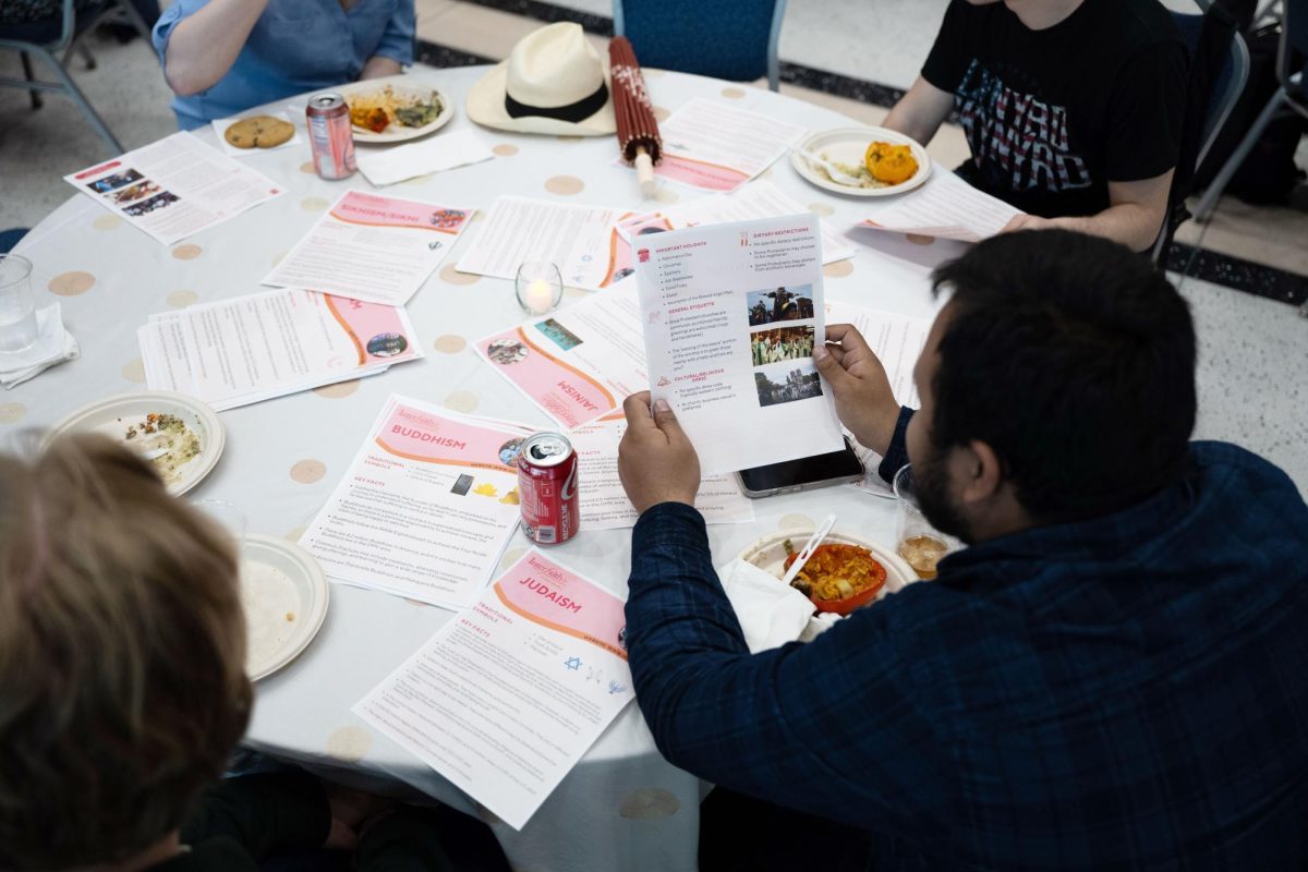 Students review pamphlets summarizing key components of religions at the Interfaith Dinner in April.