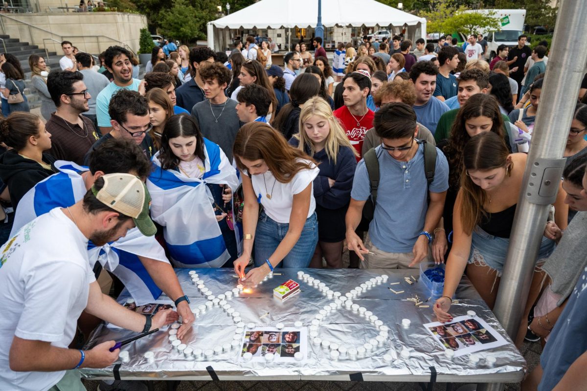 Students light candles after a vigil in Kogan Plaza celebrating the life of six Israeli hostages.