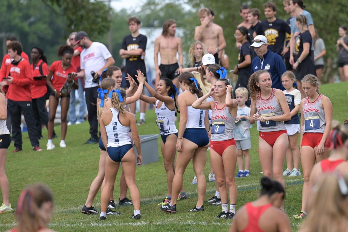 The women's cross country team hypes each other up before starting the Navy Invitational.