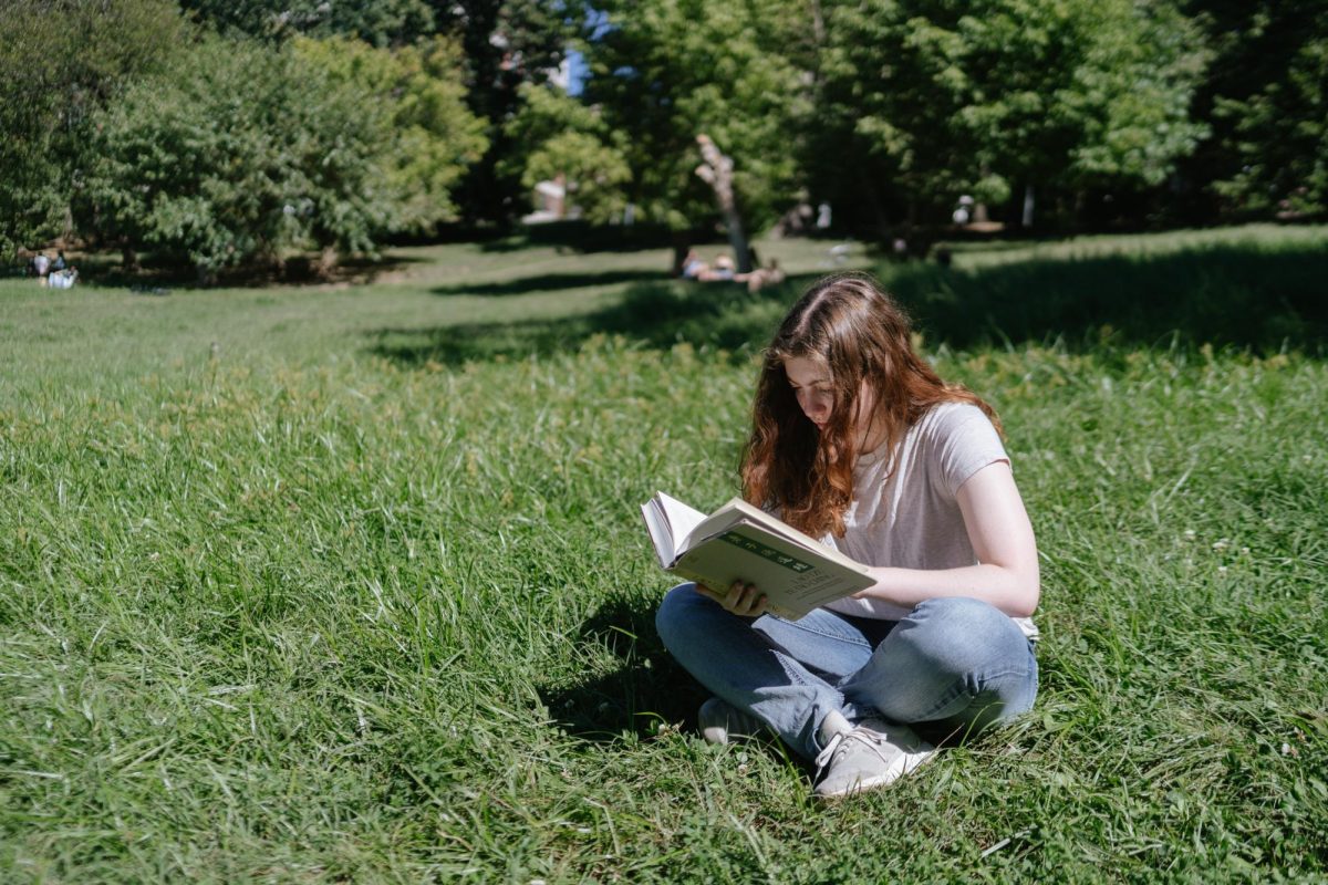 A student reads a book in Rock Creek Park.