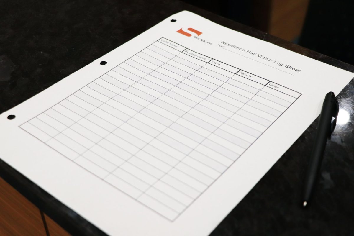 A visitor sign-in sheet sits atop a security desk in South Hall.