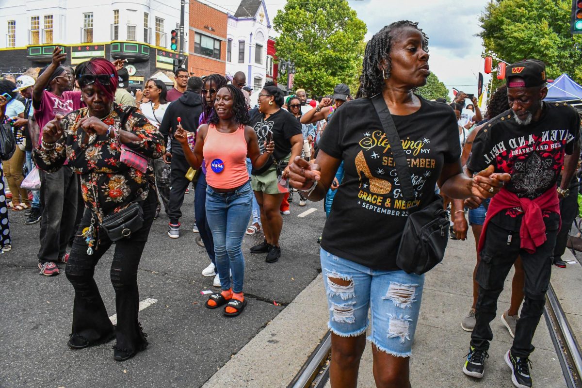 Festival attendees dance to music by OutDaBox X'Perience performing live nearby.