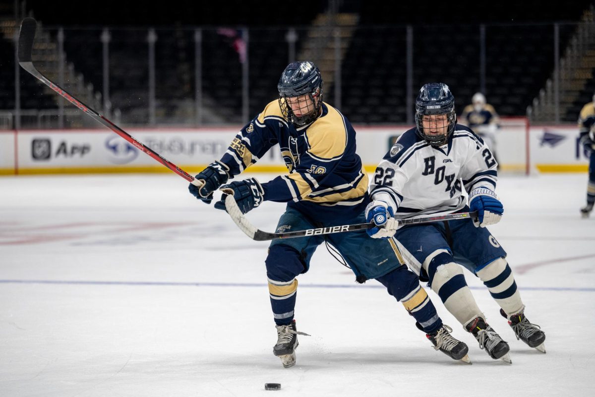 Senior forward Shawn Montgomery battles over the puck against the Hoyas during the second period of the matchup.