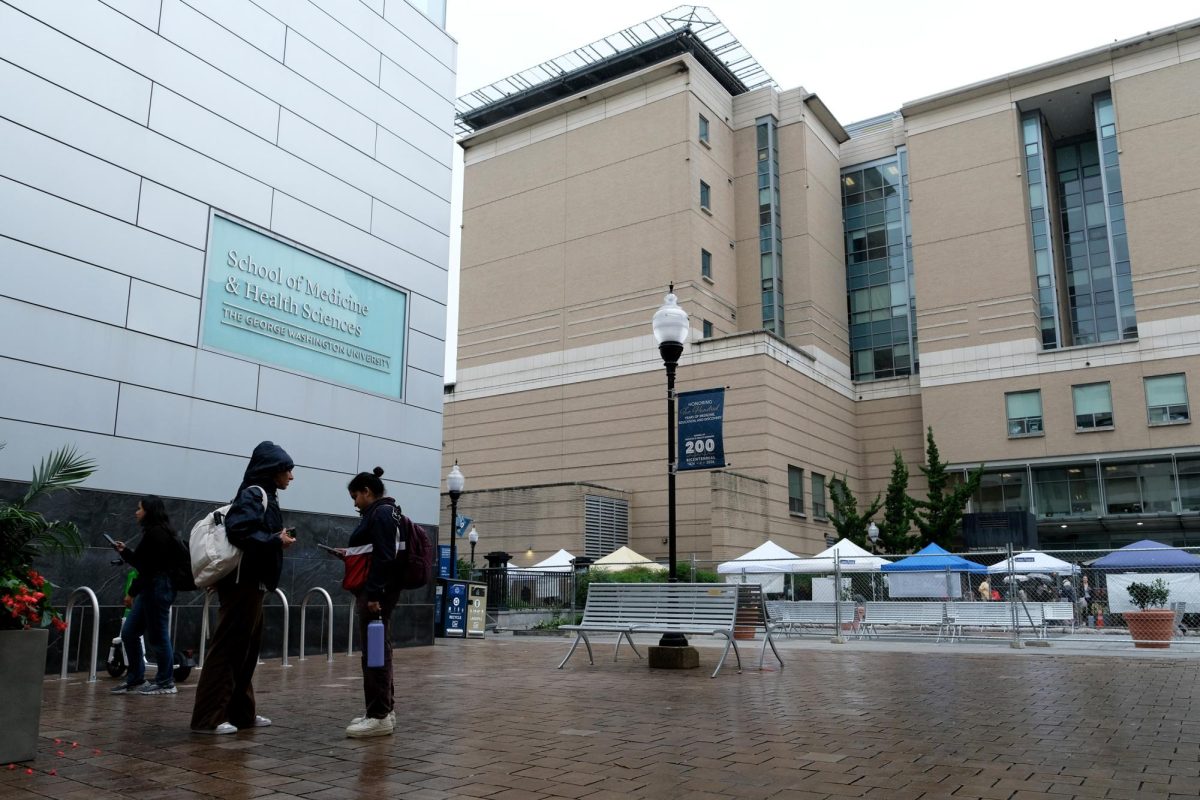 Students stand next to Ross Hall of the School of Medicine & Health Sciences.