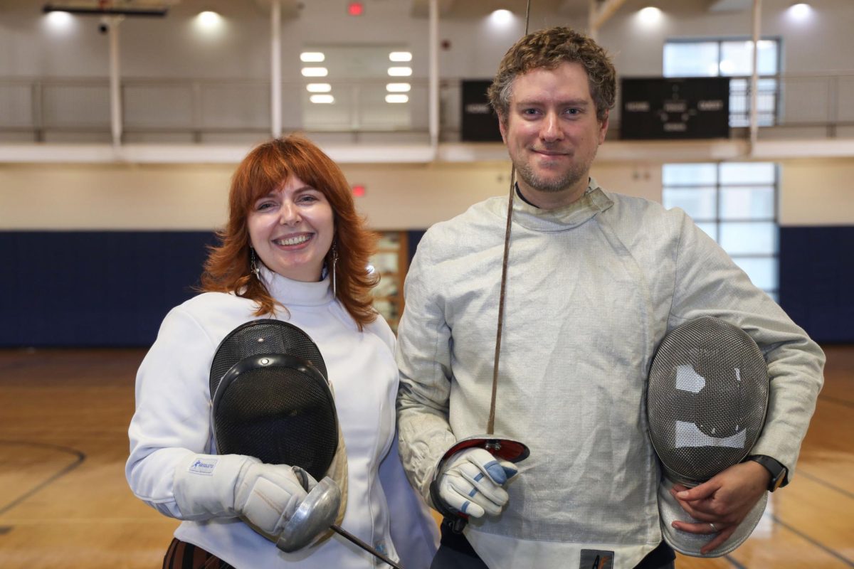 Joanna Klatzman and Hunter Higgison pose for a portrait in their fencing gear at the Lerner Health and Wellness Center. 