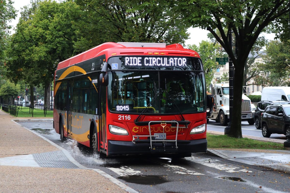 A Circulator bus hits a puddle on Constitution Avenue.