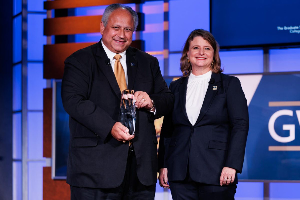 Secretary of the Navy Carlos Del Toro poses with the Dean of the College of Professional Studies Liesl Riddle as he receives the Graduate School of Political Management Alumni Lifetime Achievement Award.