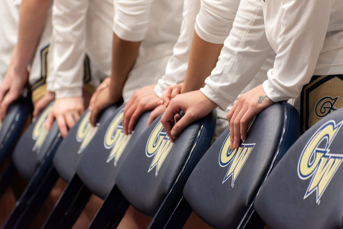 The GW women's basketball team stand behind the bench before the tipoff of a February game. 