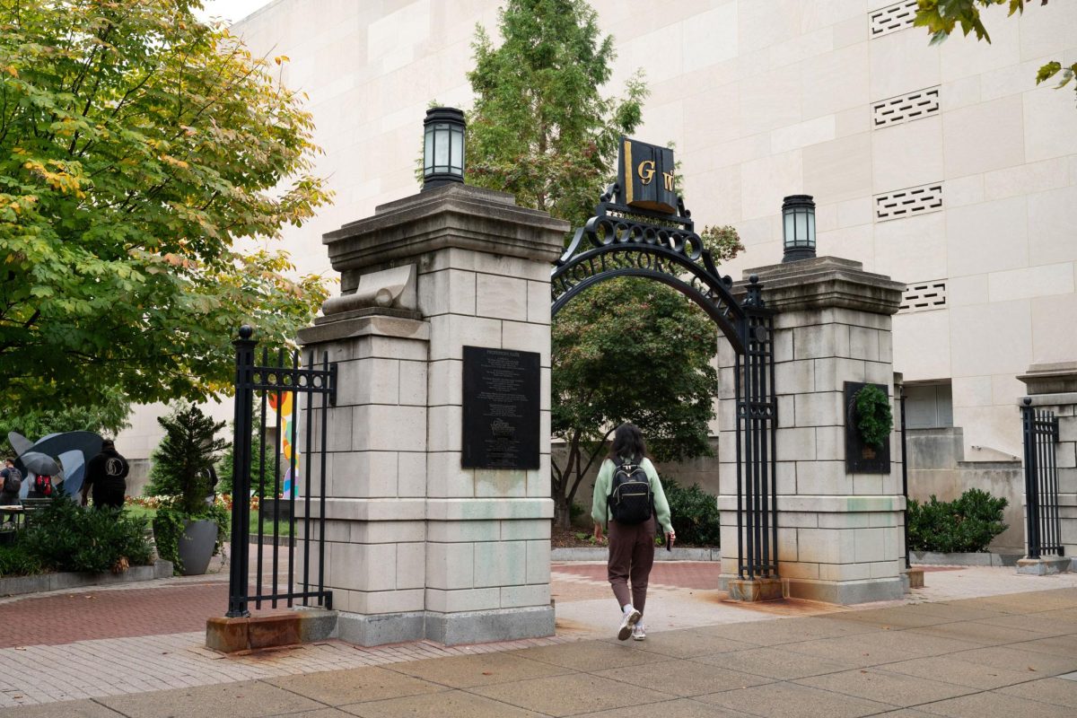 A student walks through the Professor's Gate of Kogan Plaza on a rainy day in September.