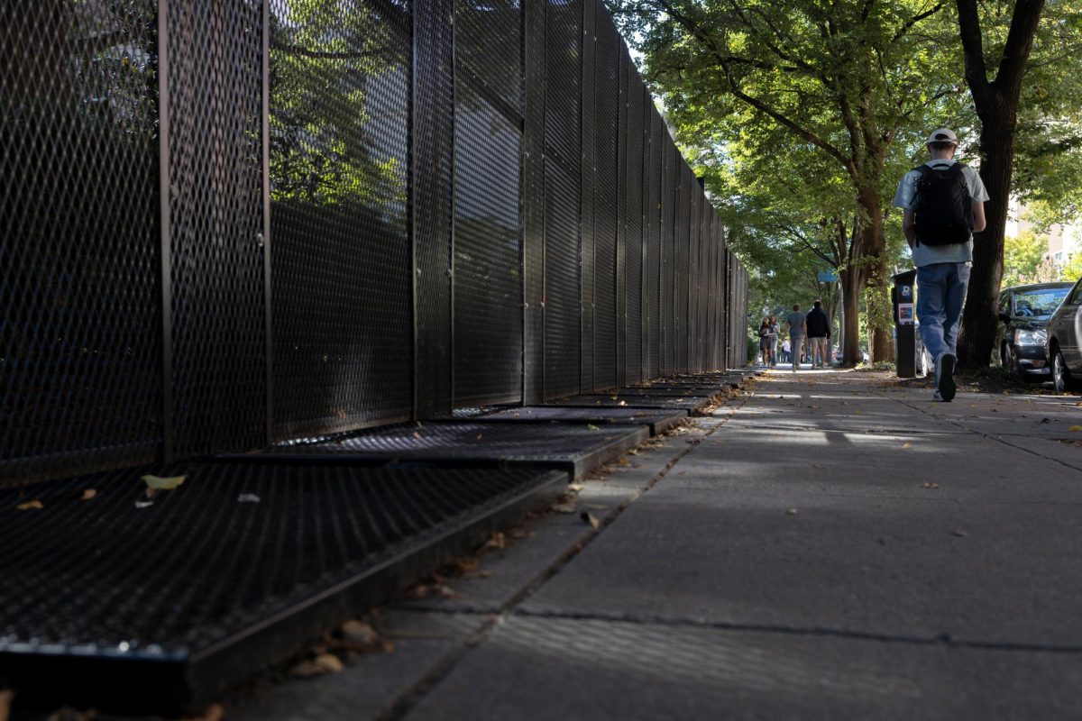 Pedestrians pass the gates that surround University Yard on H Street.