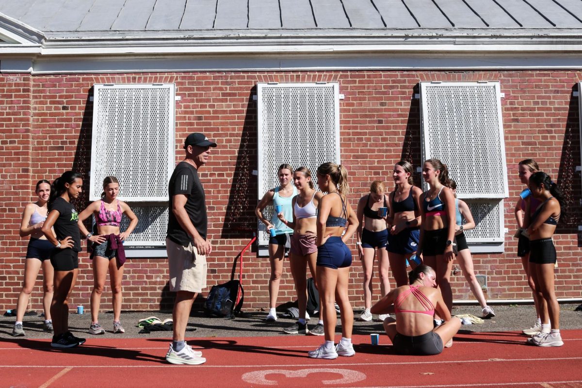 Head Coach Terry Weir talks to the women's cross-country team during a practice at Duke Ellington Track and Field.