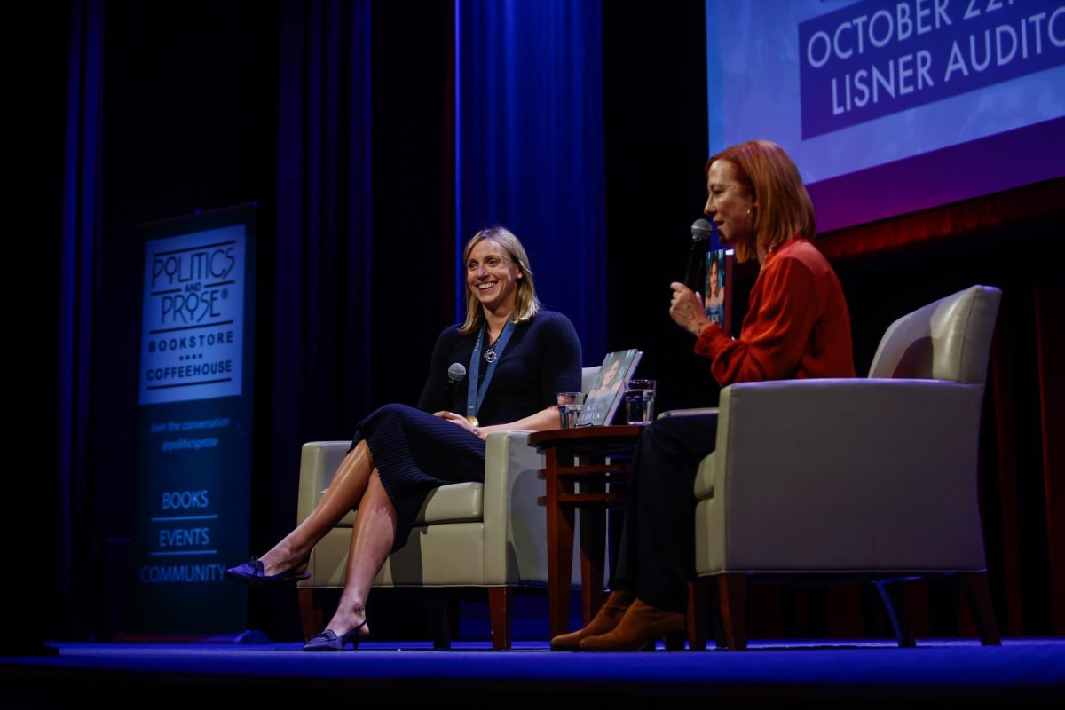 Olympic swimmer Katie Ledecky smiles towards the audience while MSNBC correspondent Jen Psaki introduces her.