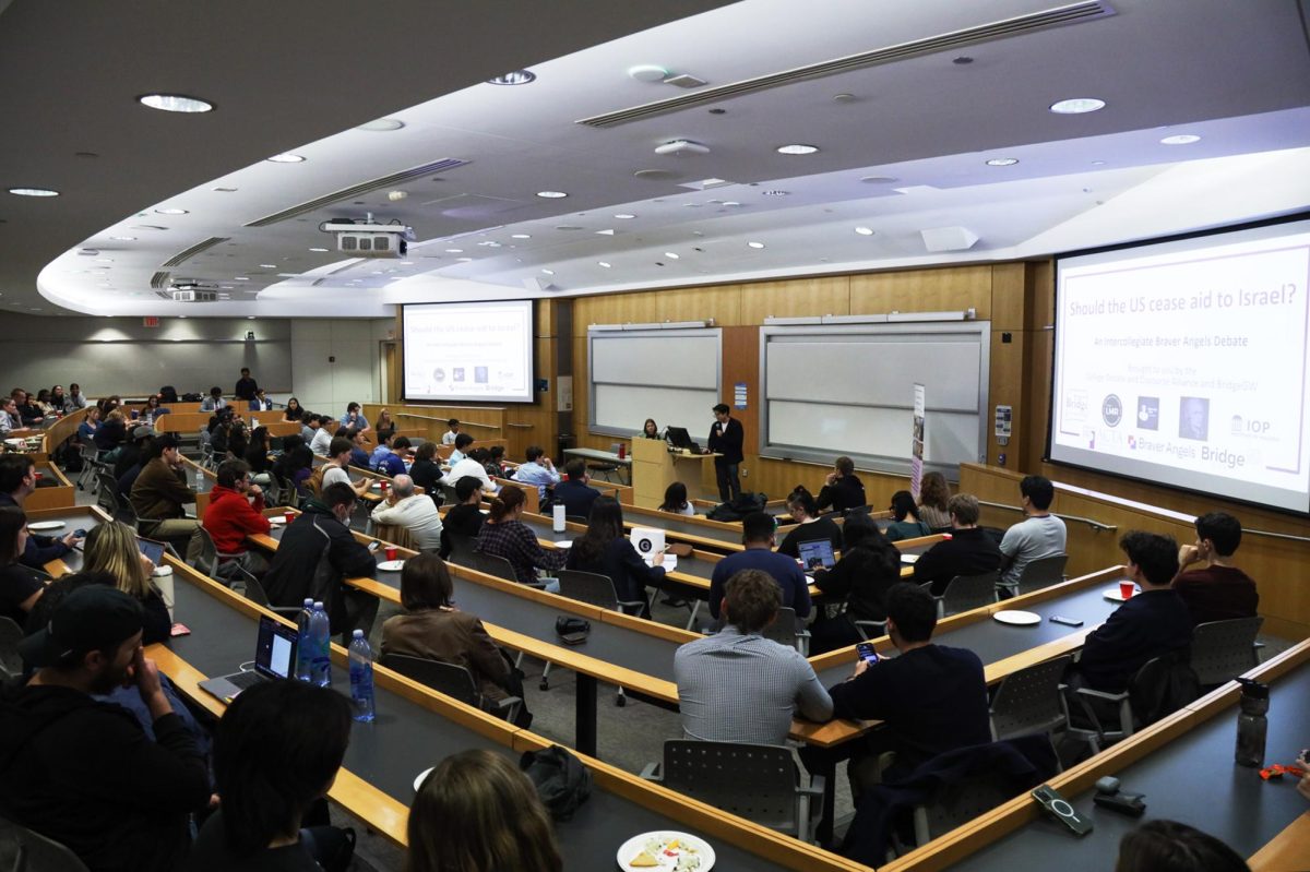 A full classroom of students sit in Duques during the debate discussing sending aid to Israel.