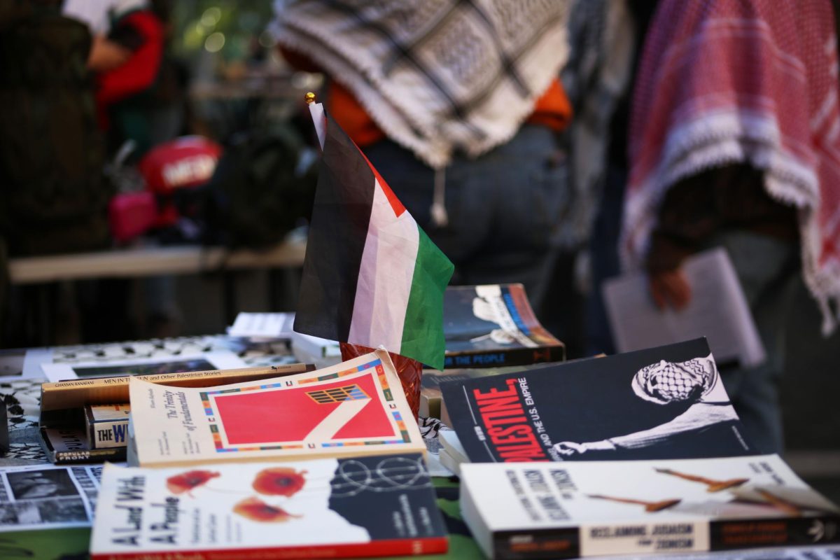 Books, flags and keffiyehs line the Students for Justice in Palestine table.