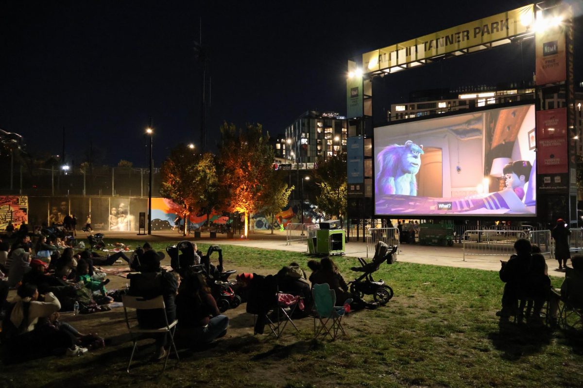 A crowd watches Monsters, Inc. at Alethia Tanner Park ahead of Halloween.