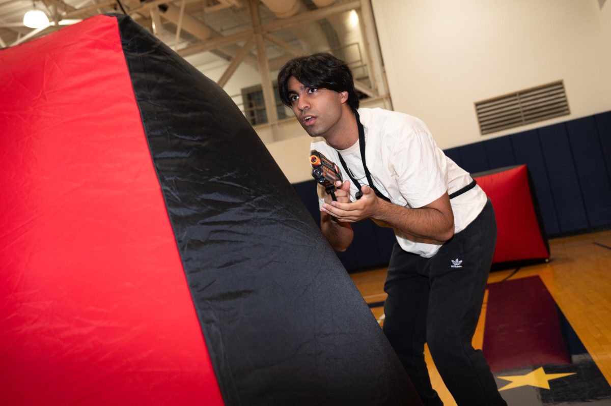 Raz Shah takes cover behind a barrier, looking to tag the enemy on the basketball courts inside the Lerner Health and Wellness Center.