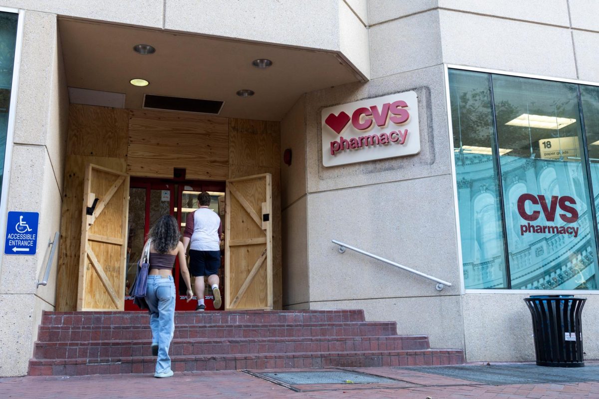 Students enter the Western Market CVS Pharmacy, now boarded up in preparation for the election.