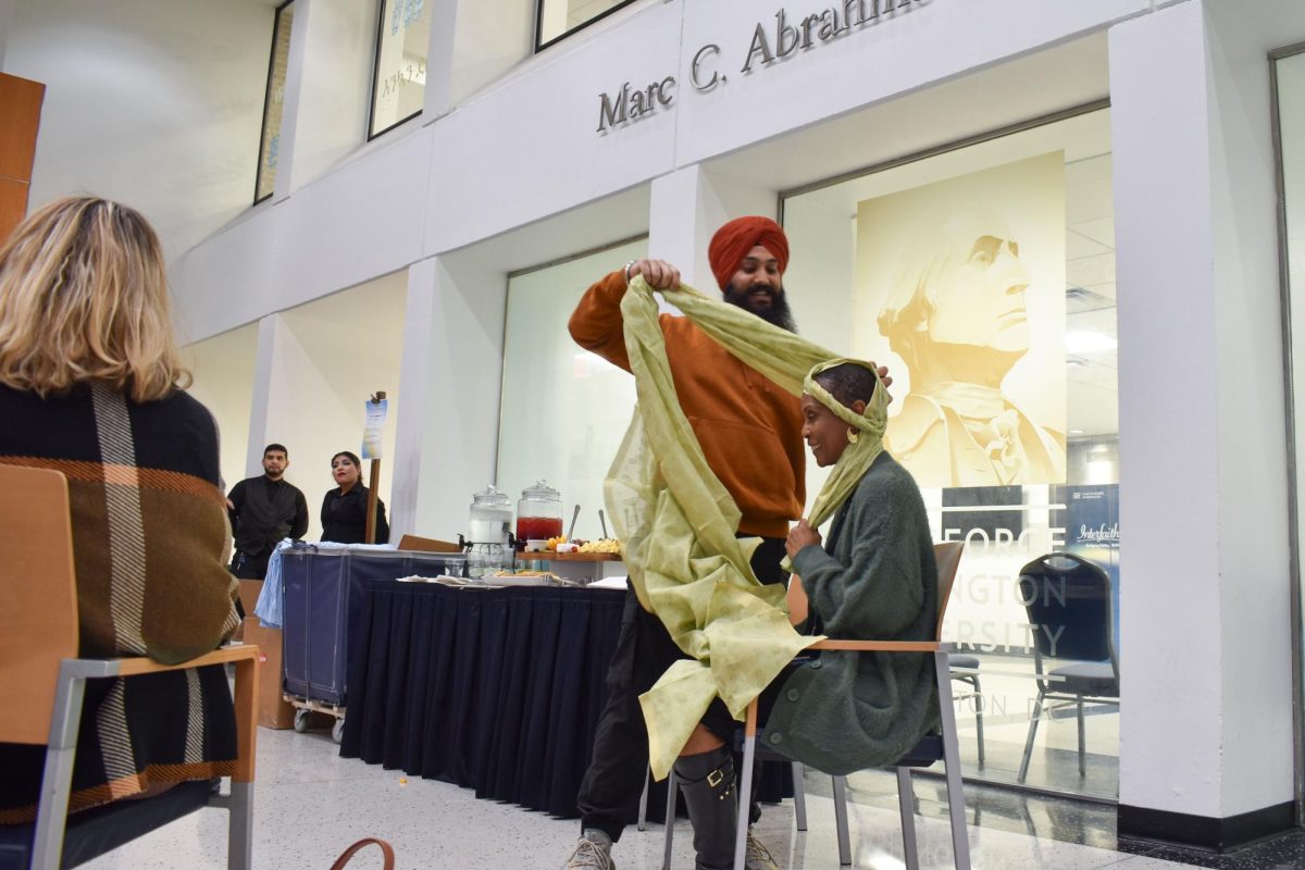 Gurdeep Singh ties a turban on Division for Student Affairs Project Manager Charon Hill-Reed as a part of Interfaith Week programming.