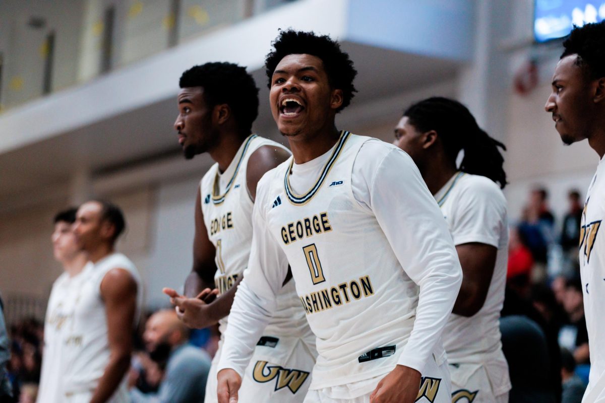 Sophomore guard Trey Autry cheers on the team from the benches during a game against American on Wednesday.