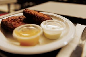 Latkes and containers of applesauce and sour cream from Loeb's NY Deli.