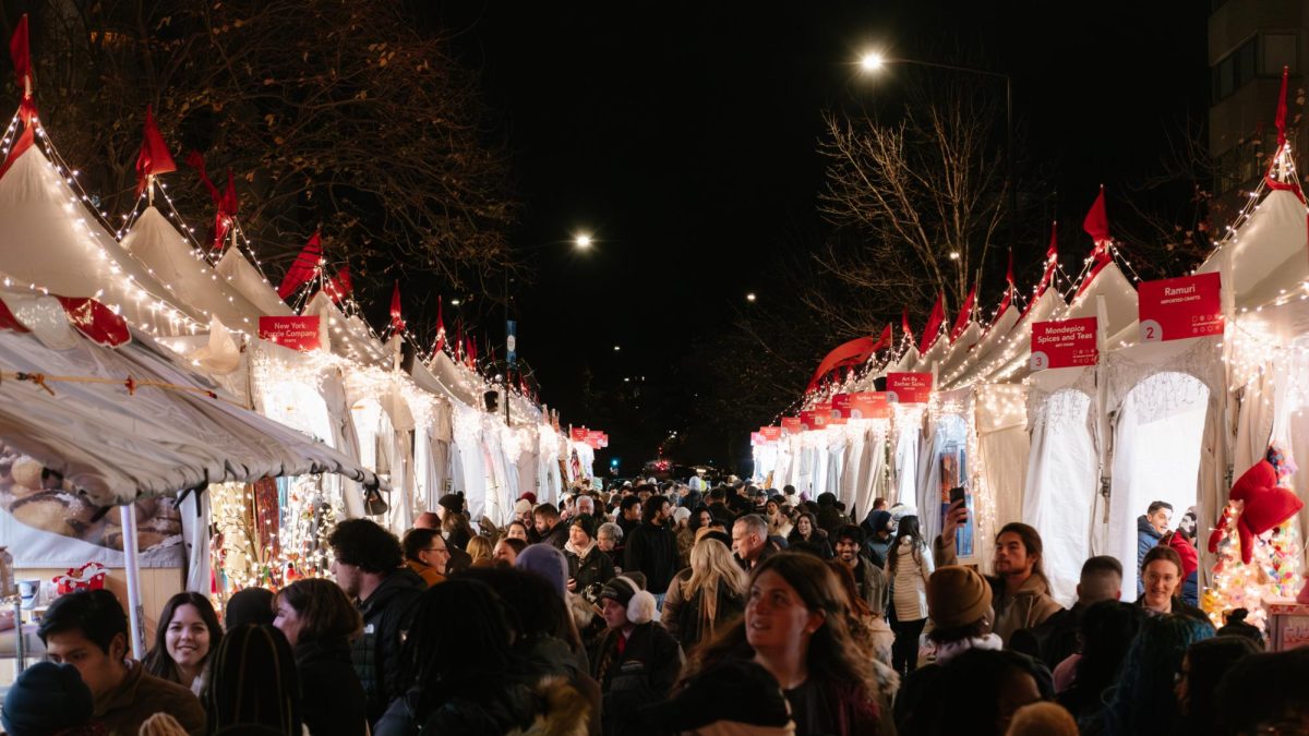 Attendees walk through the Dupont Holiday Market, checking out vendors and items for sale.