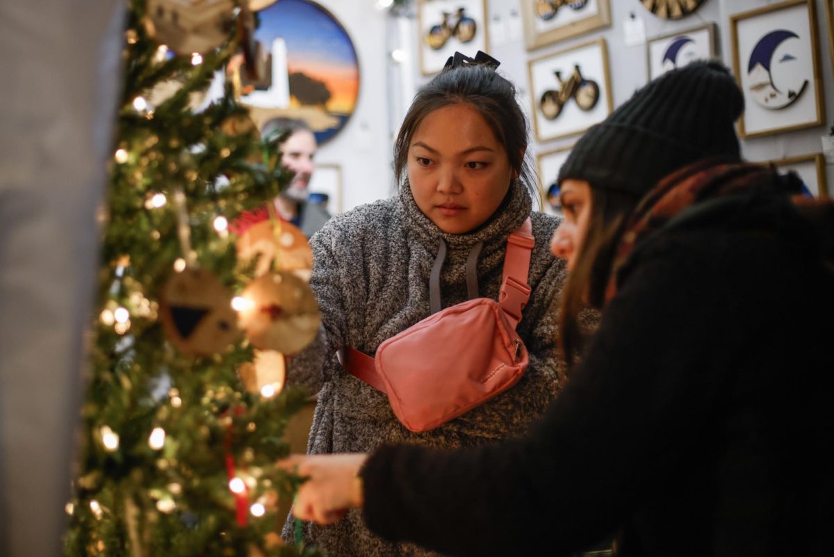 People pick out ornaments inside a vendor's tent at the Dupont Holiday Market.