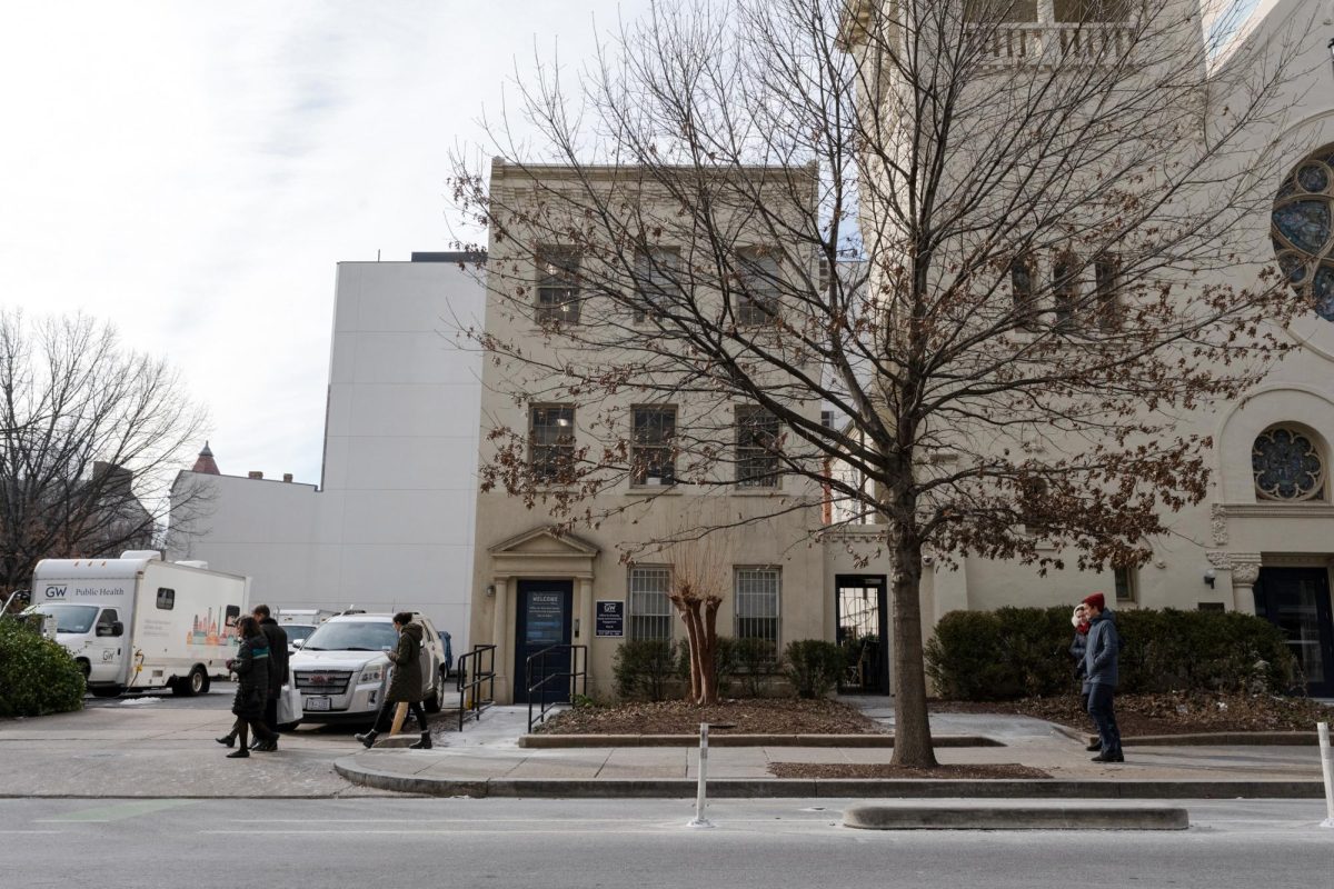 Pedestrians walk across the sidewalk in front of the Title IX office along 20th Street.