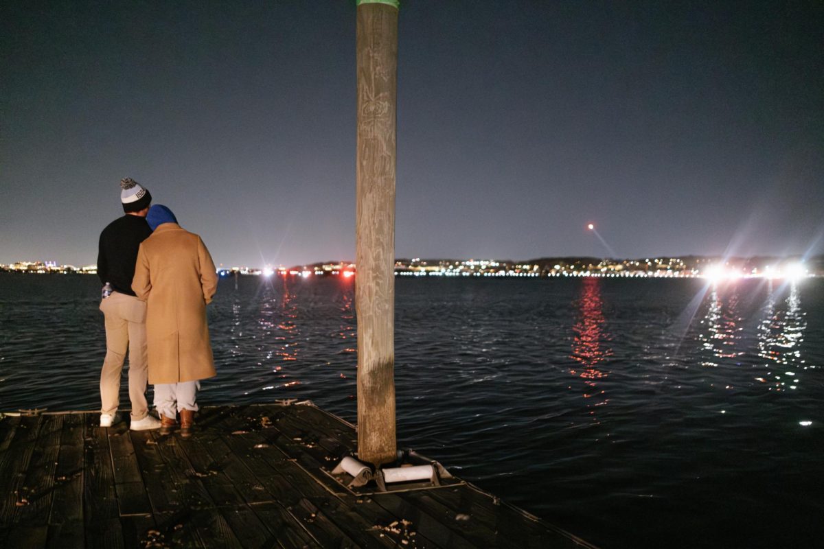 Arlington residents Brittany Wieland and Avery Shepard watch the search efforts over the Potomac River.