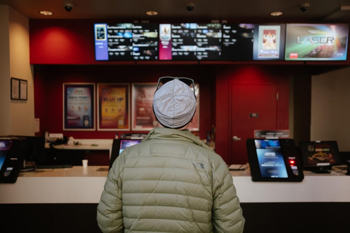 A man chooses a movie to view at the box office at AMC Georgetown.