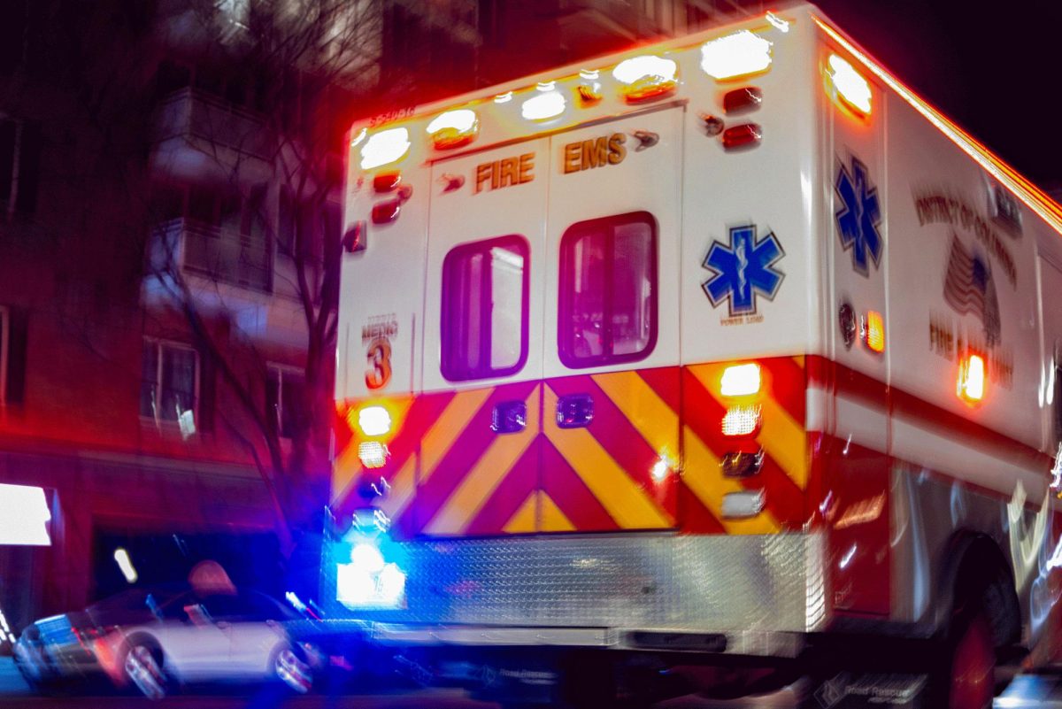 A DC Fire and EMS ambulance drives down 23rd Street while responding to a call.