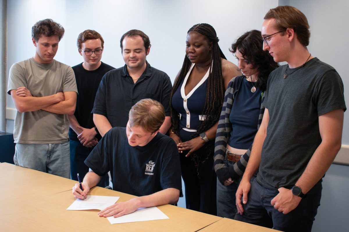 SGA President Ethan Lynne signs a executive order Tuesday.