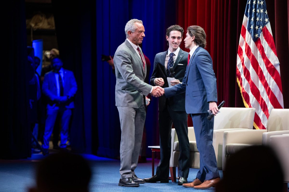 Secretary of Health and Human Services Robert F. Kennedy Jr. shakes hands with College Republicans Vice Chairman Paul Lieb and Turning Point Foggy Bottom President Ryan Van Slingerland.