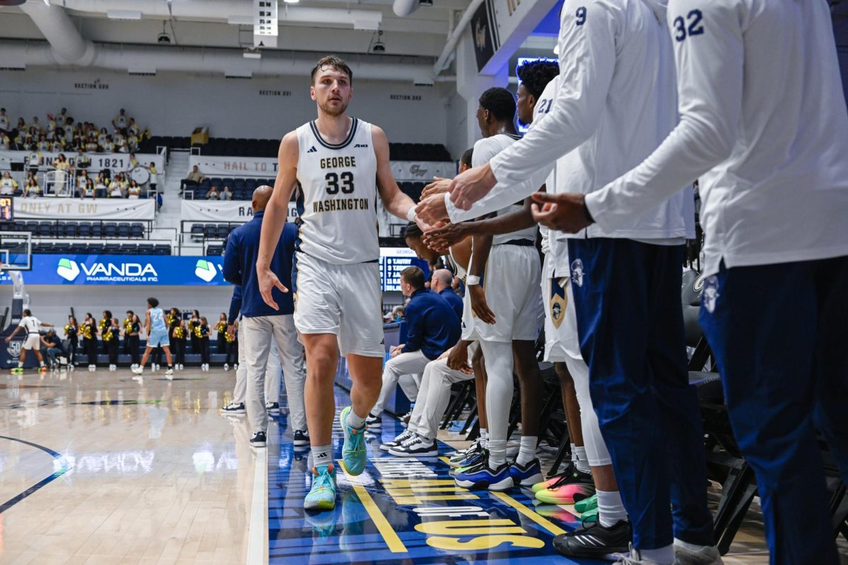 Graduate forward Luke Hunger high fives his teammates during a game against the University of Maine in November.