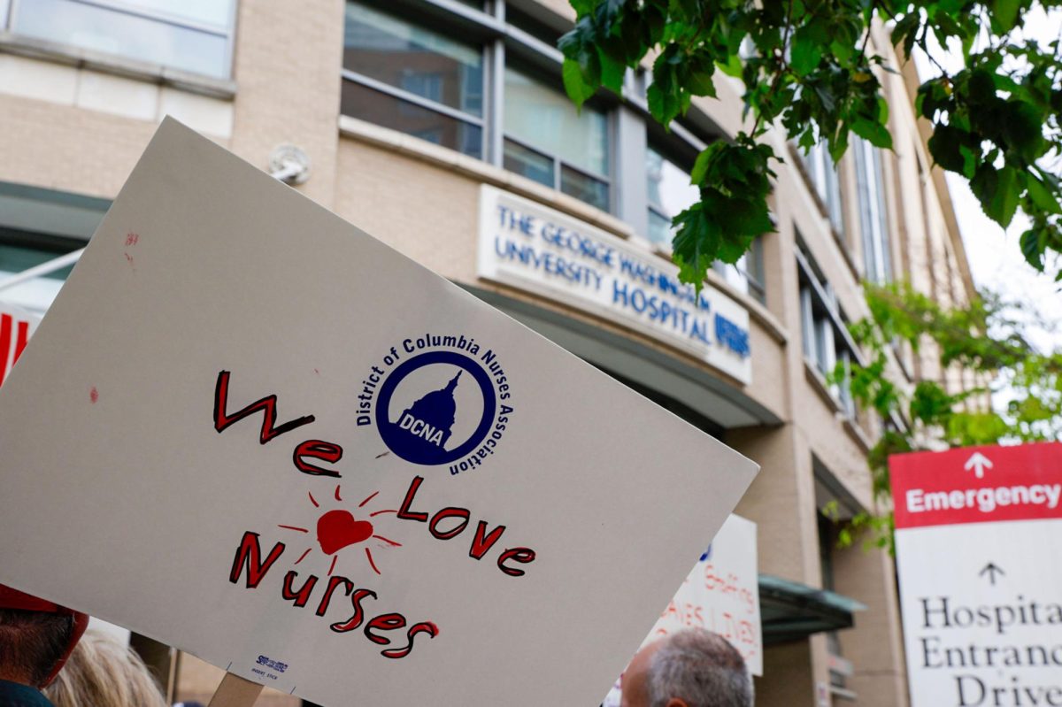 Nurses hold up signs in front of the GW Hospital during a protest in April.