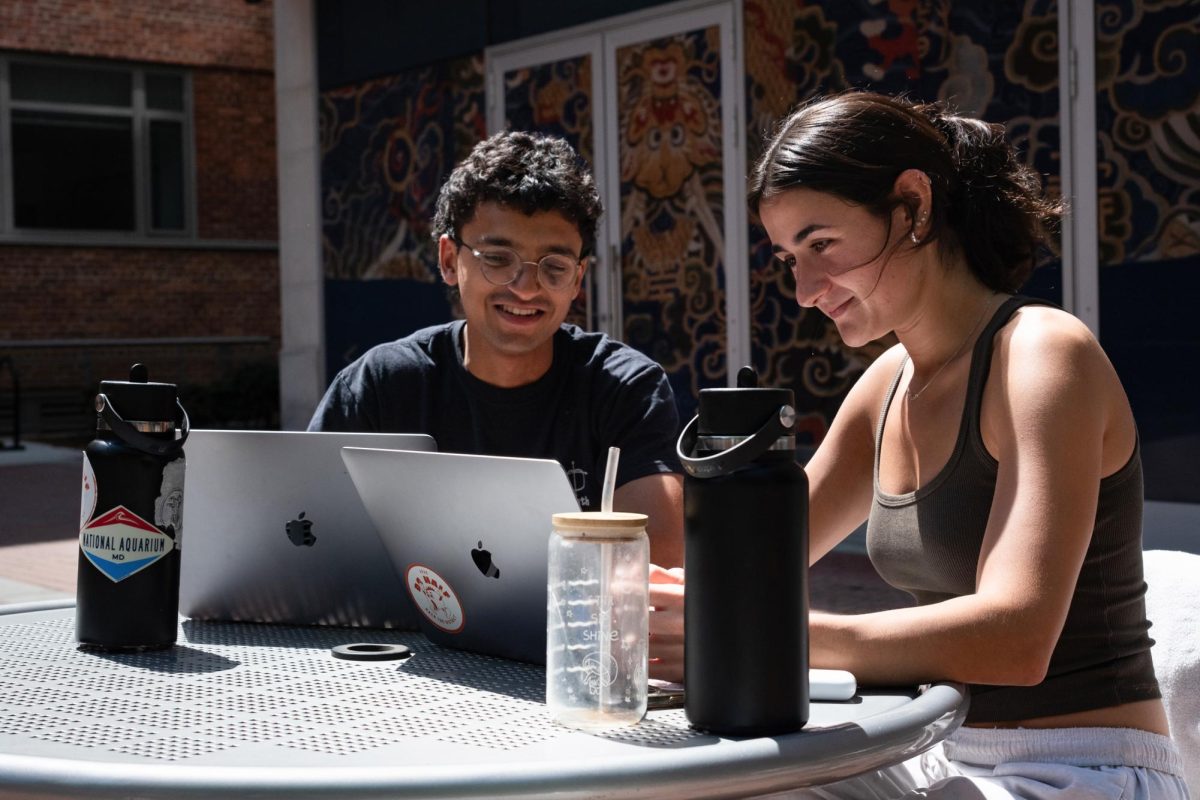 Seniors Asim Ibrahim and Piper Hogg work on their computers in University Yard.
