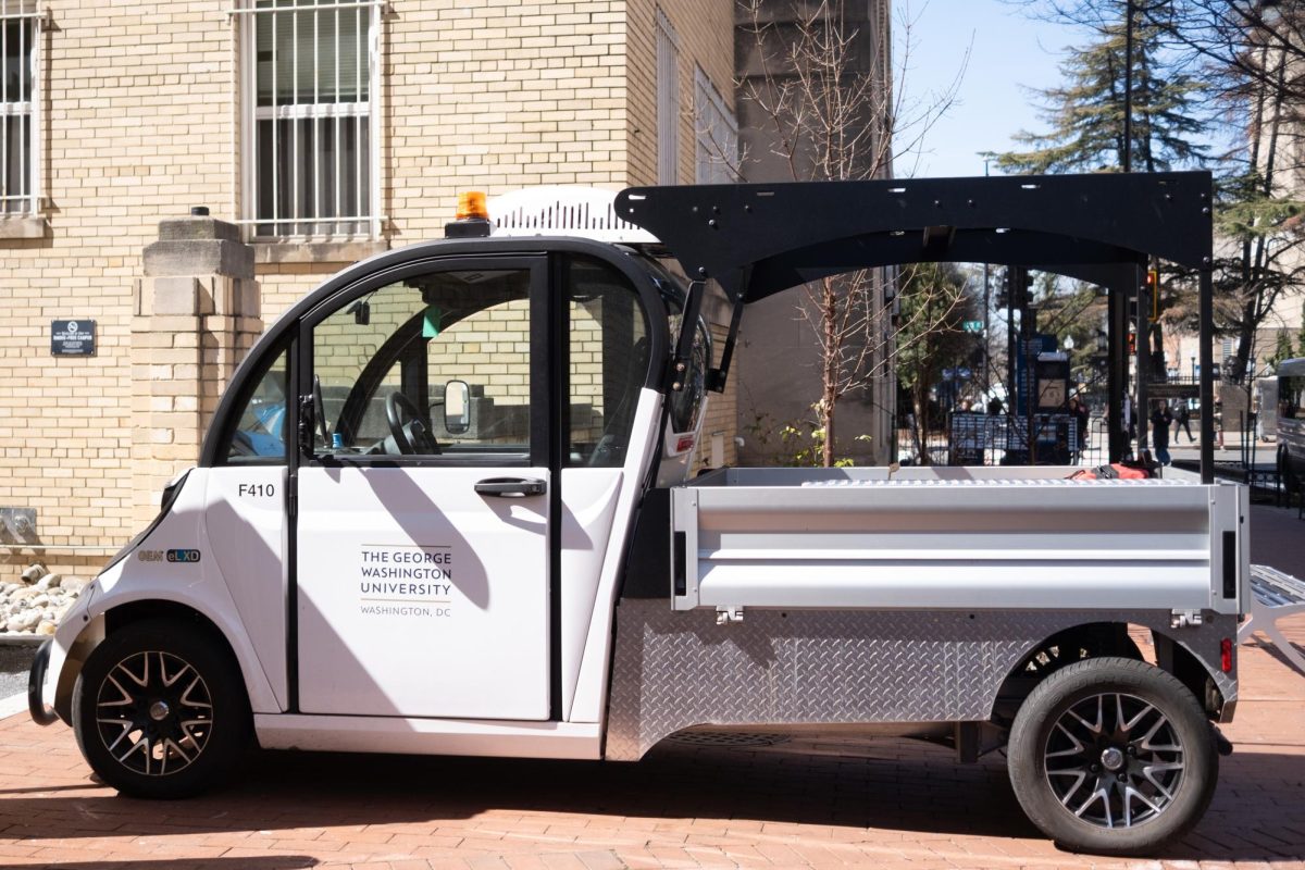 An electric maintenance cart is parked on campus.